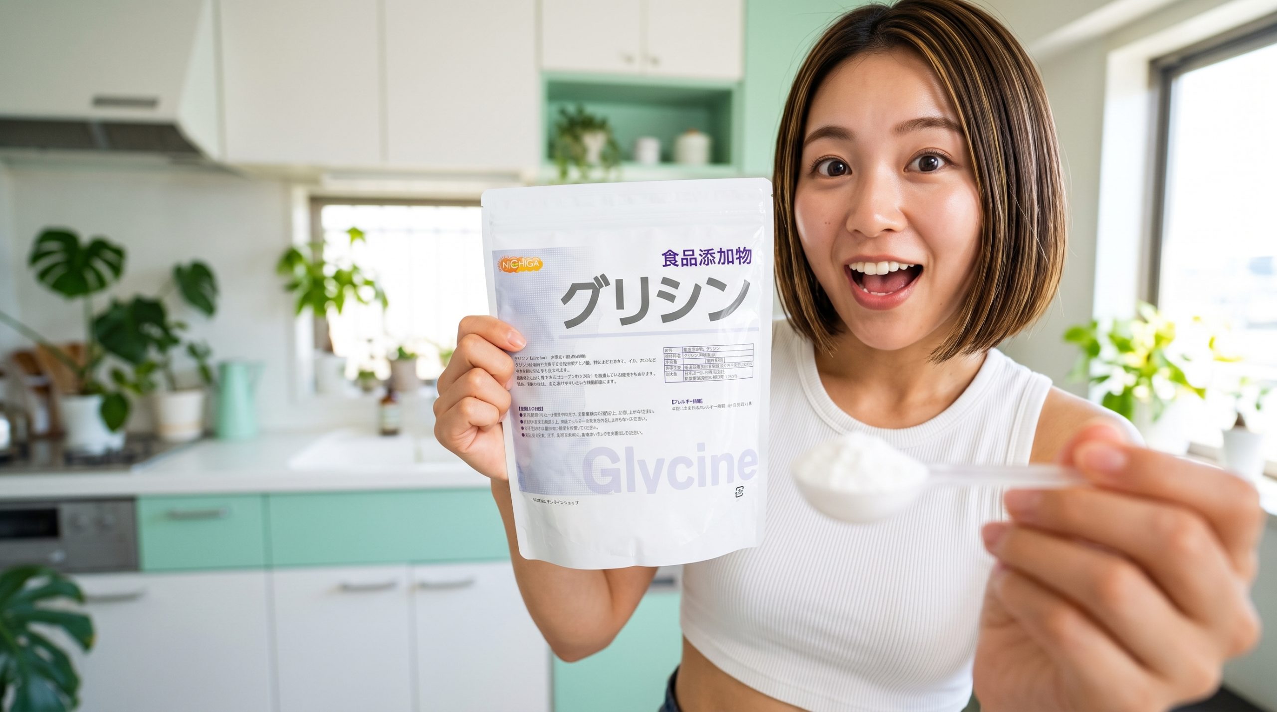 明るいキッチンで、ニチガのグリシンパウダーのパッケージと白い粉が山盛りの計量スプーンをカメラに向けて、驚いた笑顔を見せる若い日本人女性